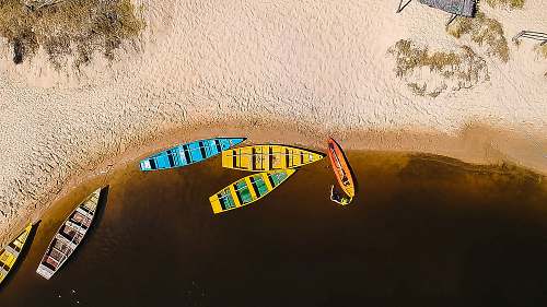 praia do sagi aerial photography of six wooden boats on calm body of water near seashore at daytime drone view